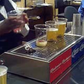 Beer dispensing system that fills cups from the bottom