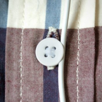 With help from an added groove on its side, this button fastens both your shirt and headphone cable.